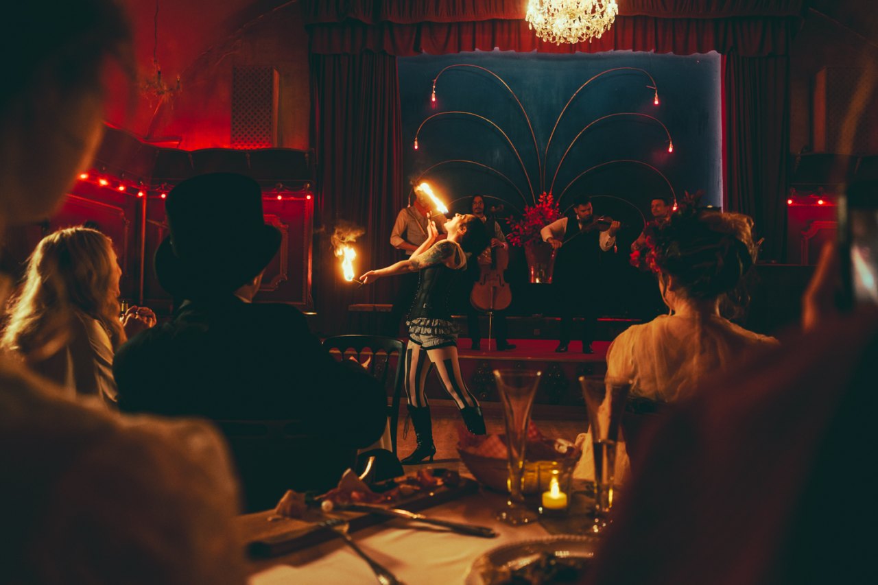 A vibrant scene from the Chat Noir experience featuring performers and audience interaction